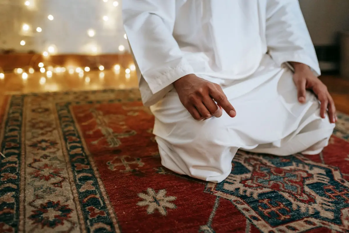 A man praying on a rug