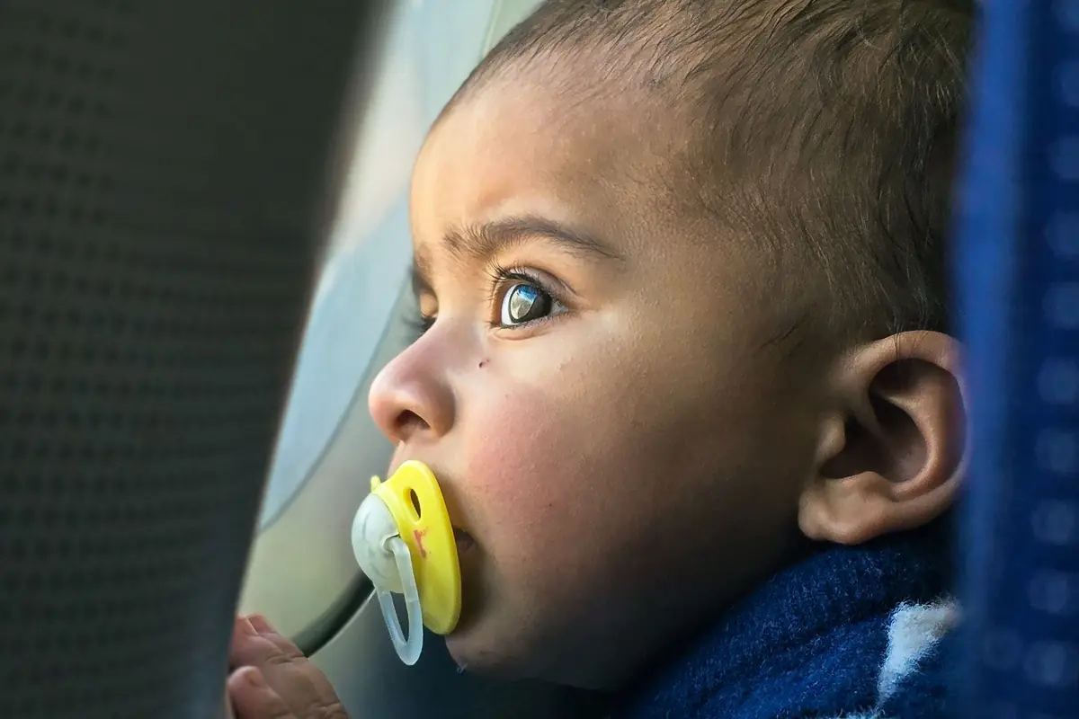 A baby looking out of an aircraft window