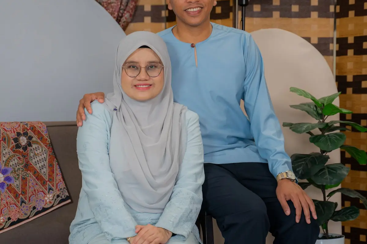 A couple smiling in traditional Malay clothing