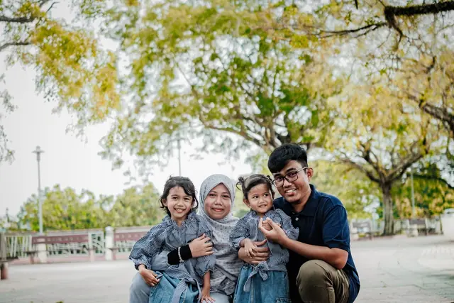A happy family smiling together in a park