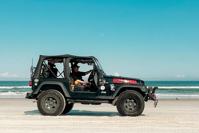 A jeep driving along a wide Florida beach