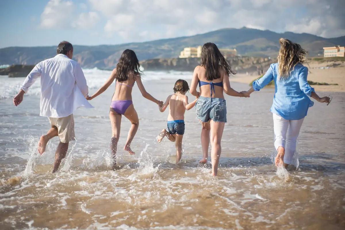 A family running together into the surf