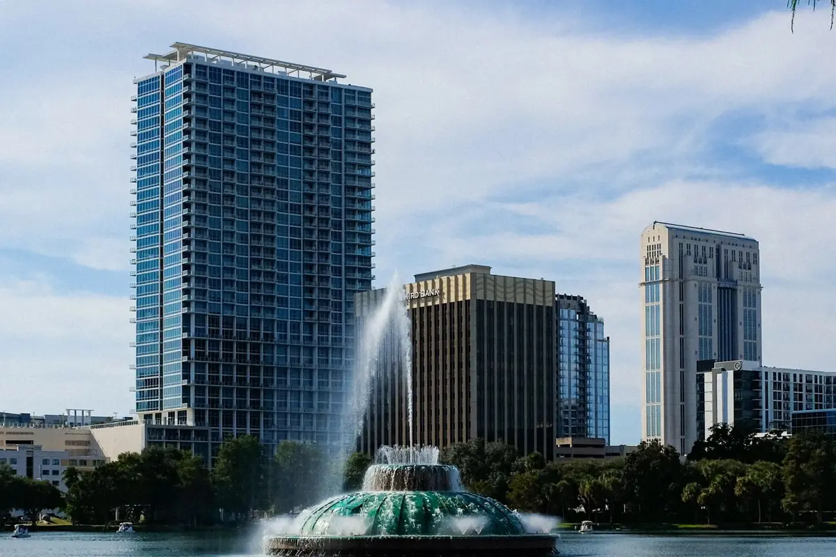 A fountain in a lake with Orlando's towers behind