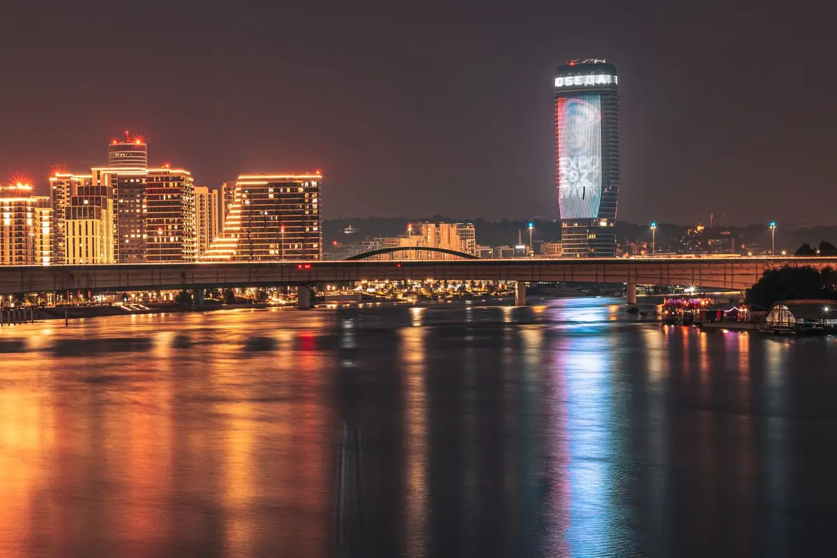 Belgrade's riverside lit up at night with a bridge