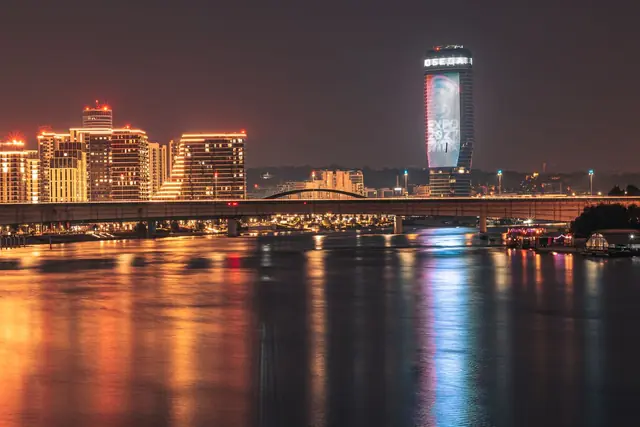 Belgrade's riverside lit up at night with a bridge
