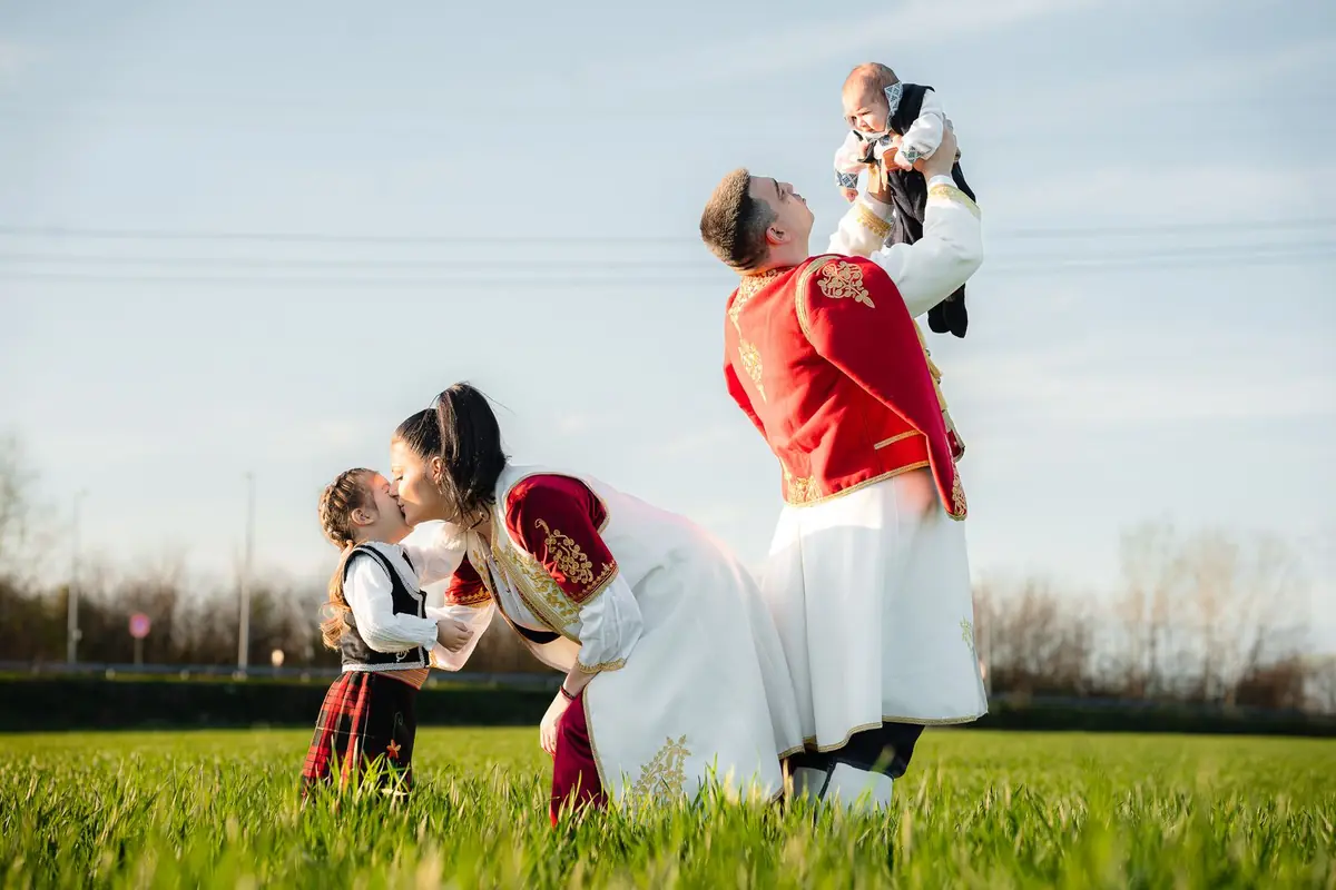 A family in traditional Serbian dress in a field