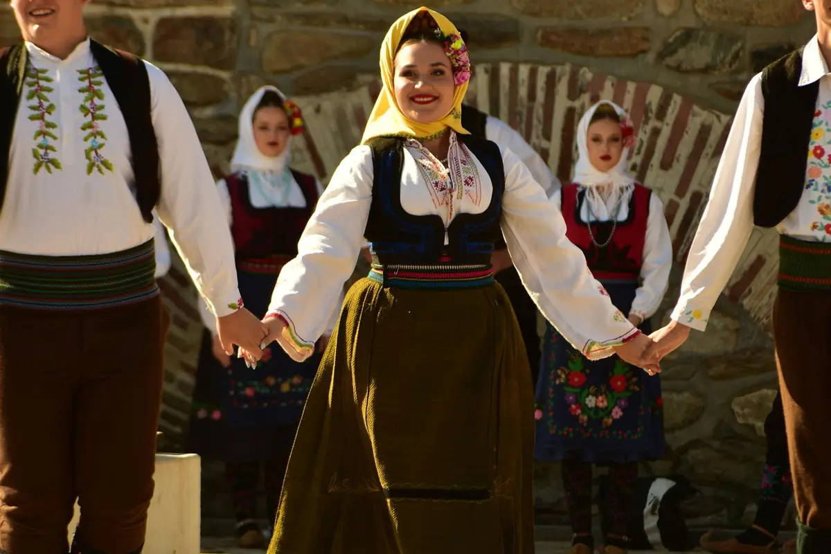 Dancers in traditional Serbian costume holding hands